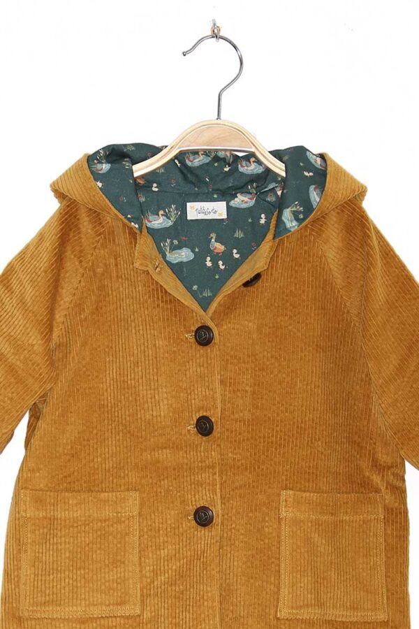 Détail de l’intérieur du manteau Cameo de Petite Corto, doublure imprimé canard sur fond bleu vert, 100% coton.